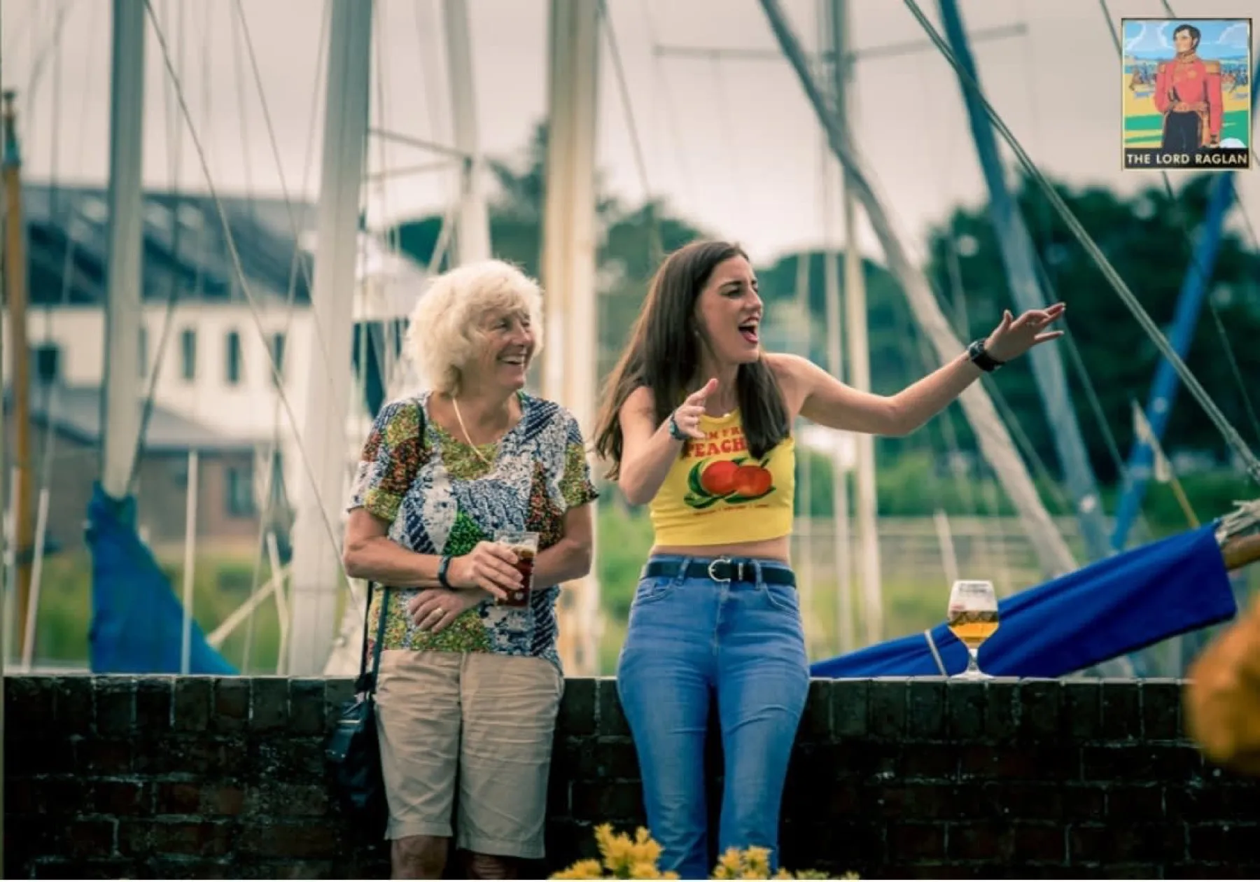 Guests laughing in front of the sailing boat masts at Slipper Mill Pond
